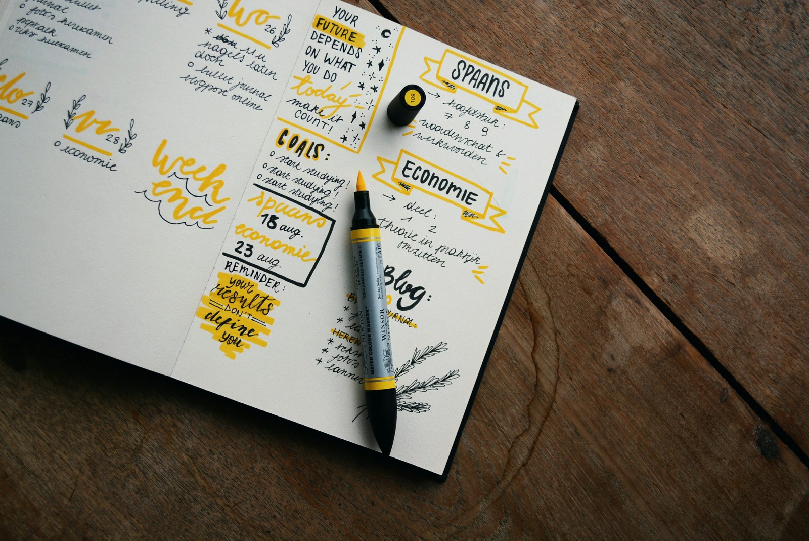 Open handwritten planner and pen on a wooden table