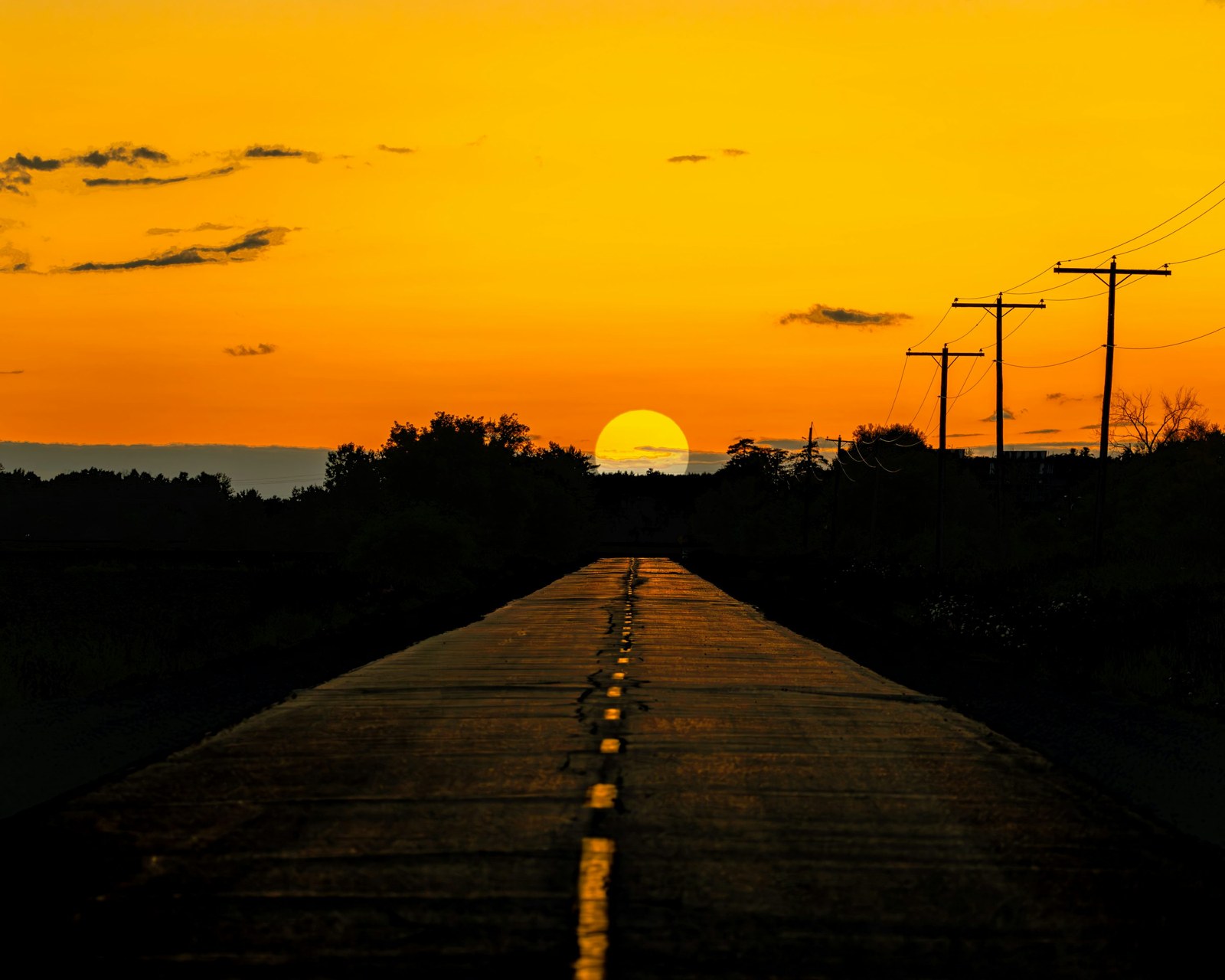 A quiet road leading toward the setting sun